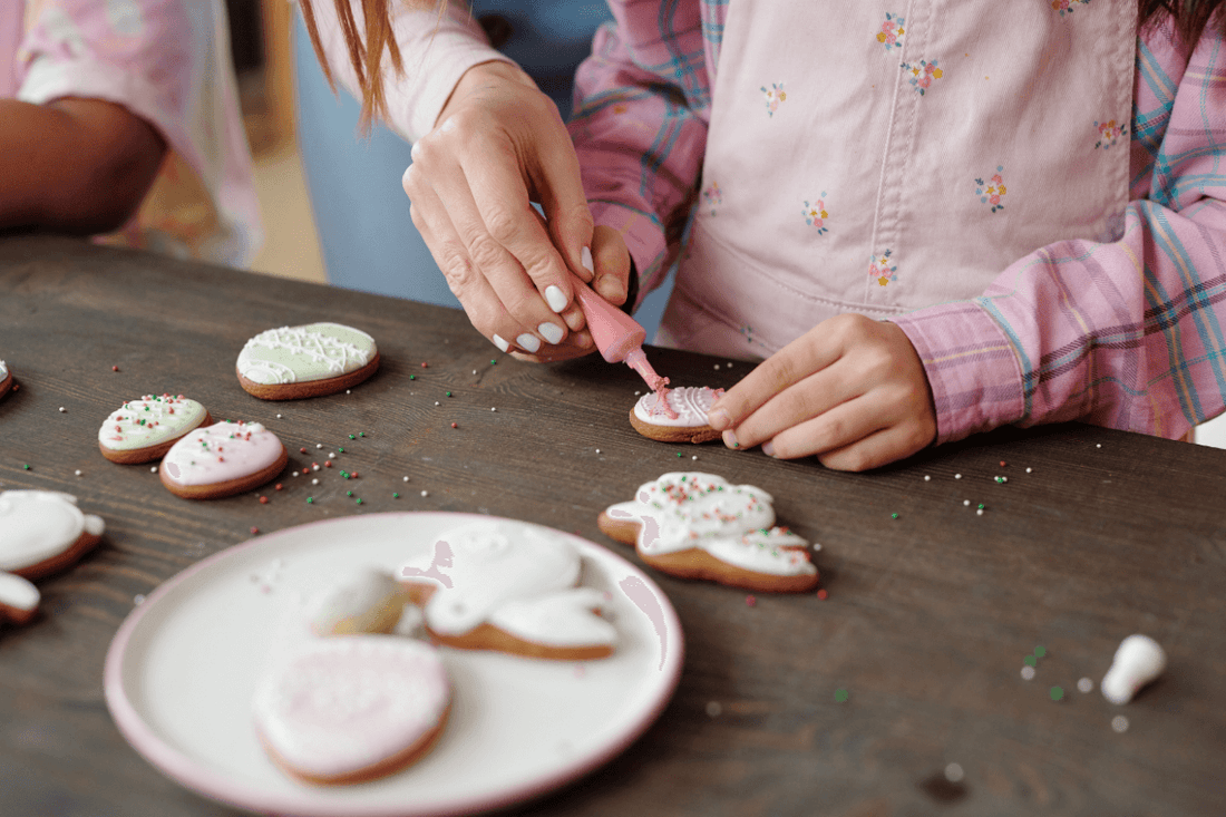 Child decorating Christmas cookies with colorful icing during a festive family activity.