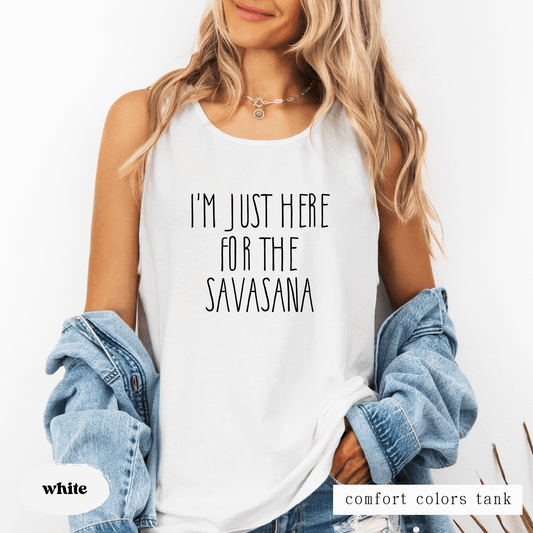 Person wearing a white tank top with text and a denim jacket on a white background featuring a tank top that says "I'm just here for the savasana"