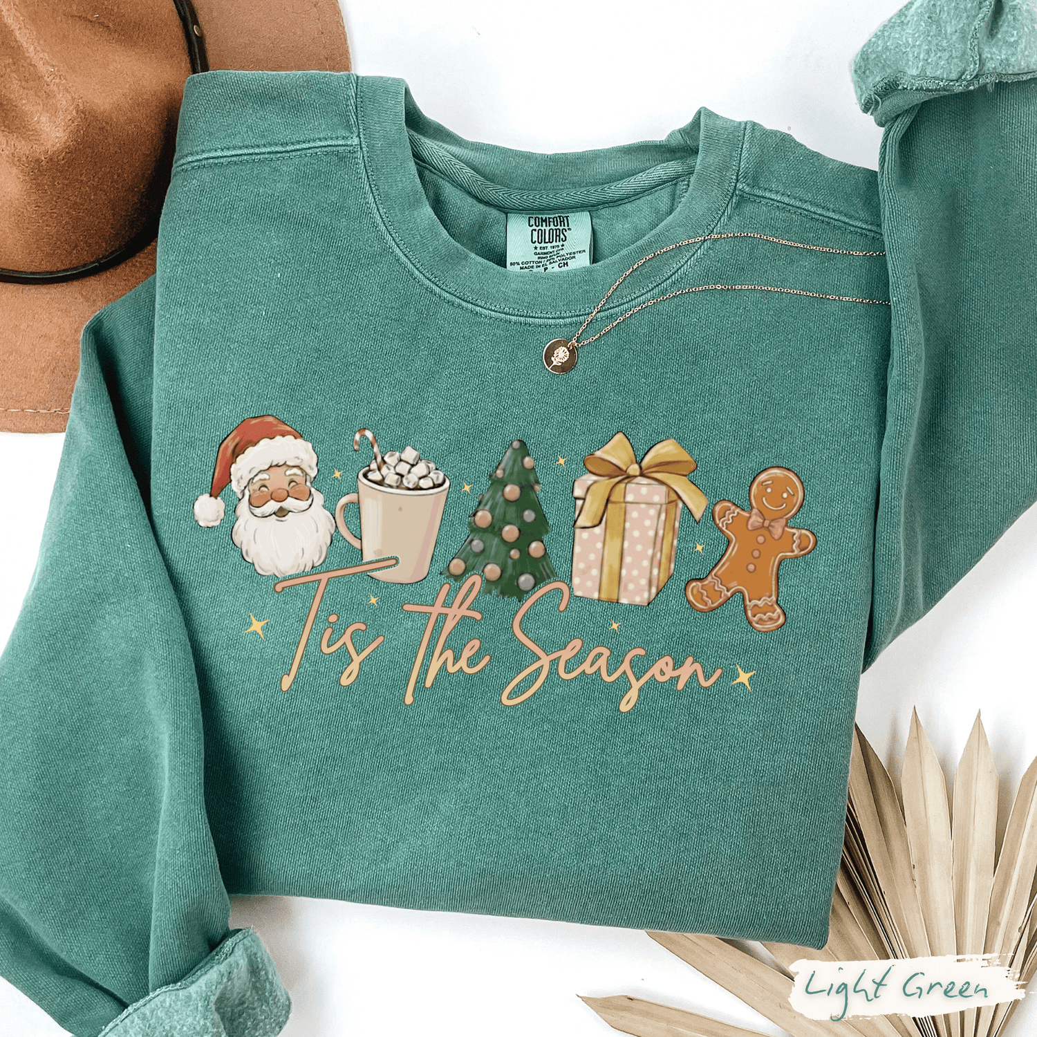 Tis the Season Christmas Sweatshirt in light green Comfort Colors with Santa, cocoa, Christmas tree, gift, and gingerbread design
