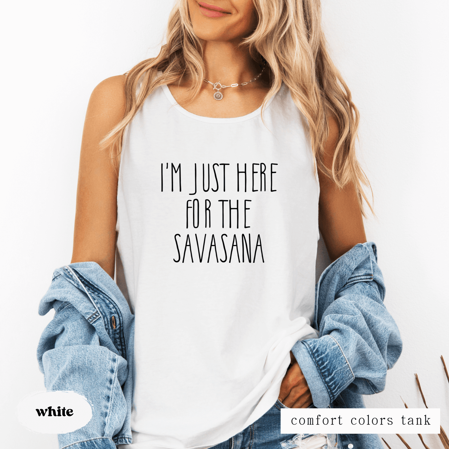 Person wearing a white tank top with text and a denim jacket on a white background featuring a tank top that says "I'm just here for the savasana"
